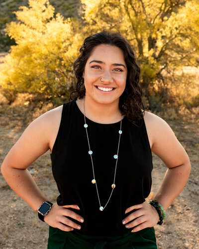 Owner of Cactus & Pine Photography smiling with her hands on hips in confident stance. 