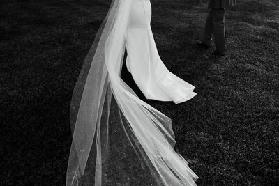 artistic high contrast black and white image of a brides wedding dress and veil taken by minnesota wedding photographer tom thornton