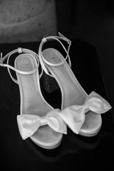 An Austin-based wedding photographer captures a stunning pair of white wedding shoes adorned with elegant bows.