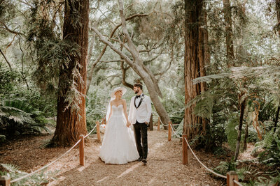 bride and groom holding hands in forest