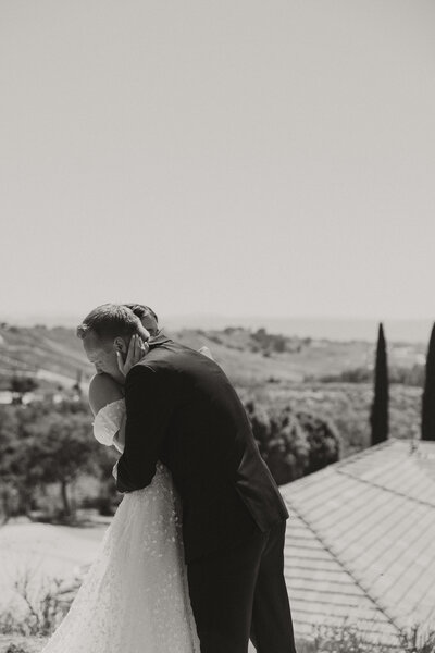 groom crying on bride shoulder, first look, black and white wedding 