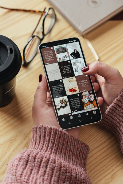 Scrolling through luxury brand content on a phone, part of the design and consultation process.