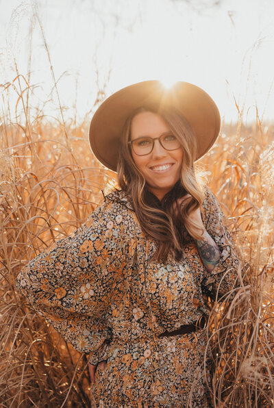 Golden hour self portrait of woman  standing in tall grass