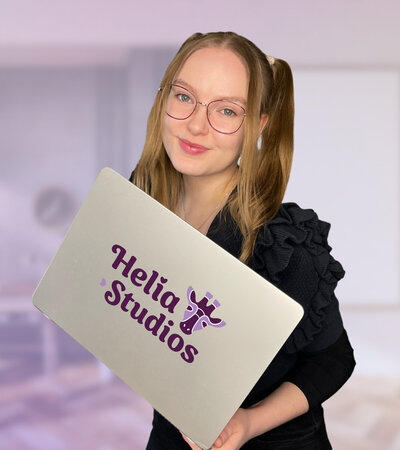 Designer Saara with laptop featuring Helia Studios logo