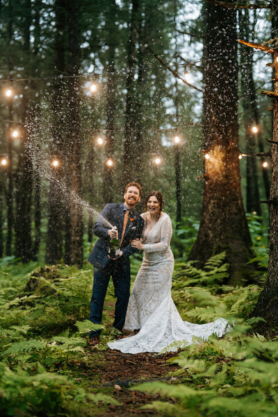 couple celebrates by popping champagne at wedding