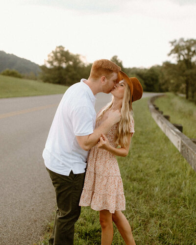 Engaged couple posing for their photo kissing.