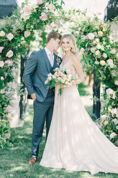 Elegant luxury wedding at Wadley Farms in Lindon, Utah, with the bride and groom posing in front of the historic stone castle and manicured gardens.