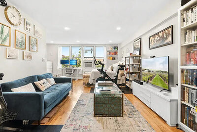 Spacious studio apartment in NYC with hardwood floors, large windows, a home gym, and modern furnishings