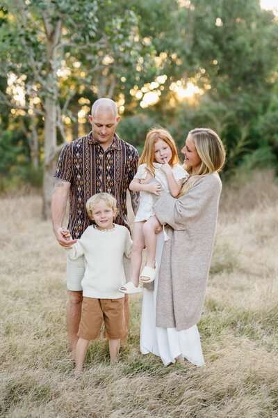 Family hugging on beach during family photoshoot with Sydney family photographer Sarah Vassallo