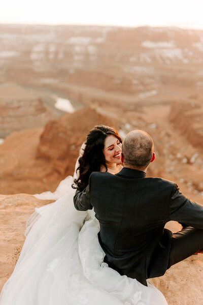 Bride and Groom at luxury wedding in Colorado hold hands and kiss