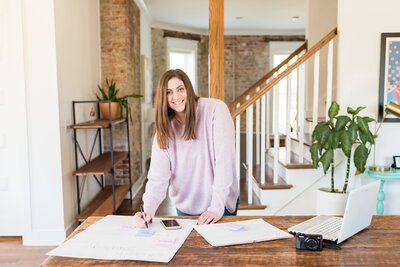 Headshot of a digital marketer and social media manager at a Nashville Airbnb where she is writing something on a giant post-it note