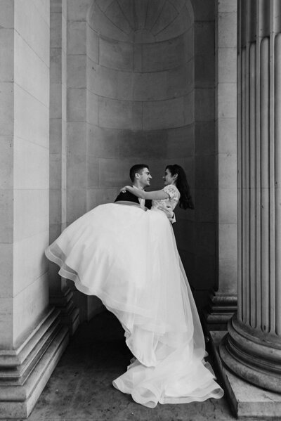 groom kissing brides cheek in street