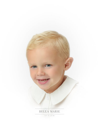 Smiling toddler boy with blonde hair and blue eyes  smiling for his heirloom portrait