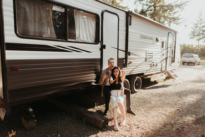 Madi and Tristan Jeno sitting in-front of their camper