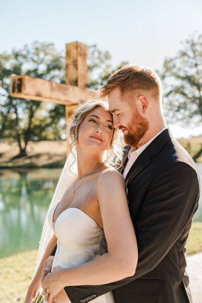 Couple looking at each other in front of cross.