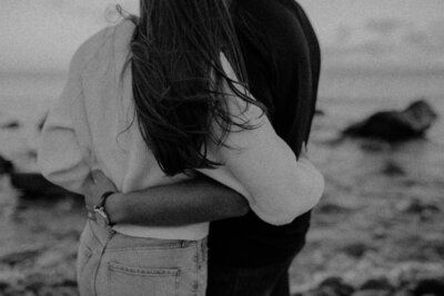 couple hugging near coastline