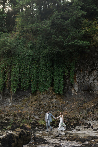 Man leading woman in the PNW at a waterfall