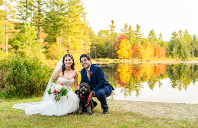 Bride and Groom with their dog looking at camera