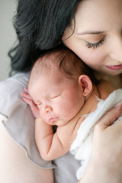 Newborn baby clinging to mom's chest