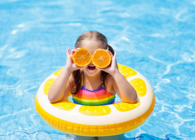 The little girl in her yellow rubber floats enjoys a cheerful time in the water
