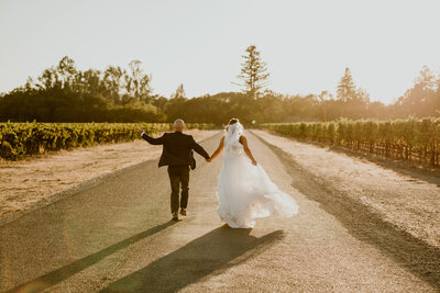 Couple running hand-in-hand into the sunset during their fall Sonoma elopement