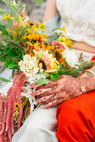 wedding photos of floral boquet and couple holding hands with henna  tattoos