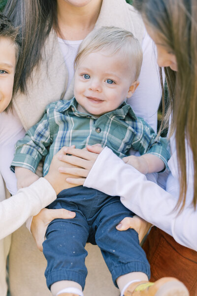 Close up of siblings cuddling baby brother during family session at Mansion at Fort Hunter