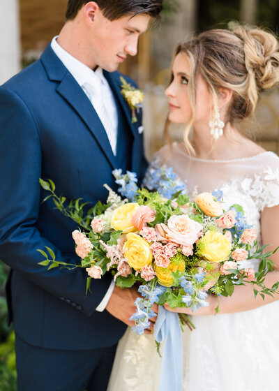 A bride holds her stunning pastel bouquet