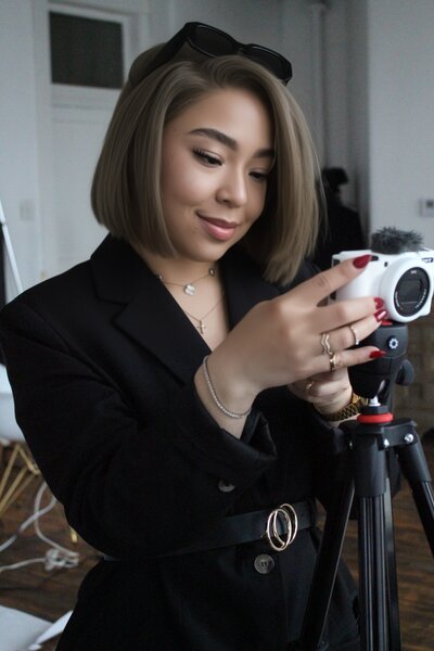 Bri Davis, Founder of Allure Atelier, using a camera