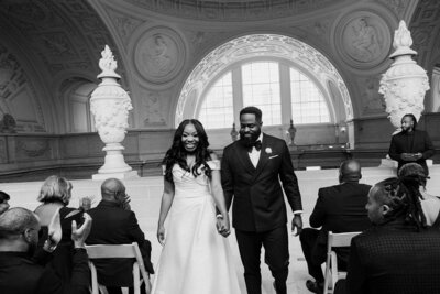 newlyweds walk down aisle in city hall building