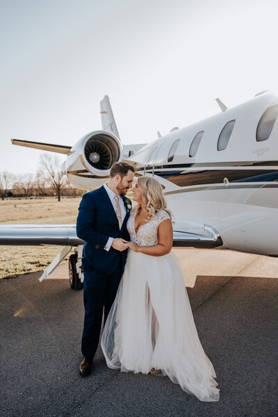 Nashville wedding photographer captures bride and groom kissing in front of airplane