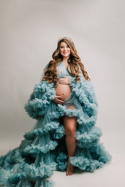 expecting mom in tan dress in front of Wahclella Falls, near Portland, Oregon for maternity photography session with Ann Marshall Photography