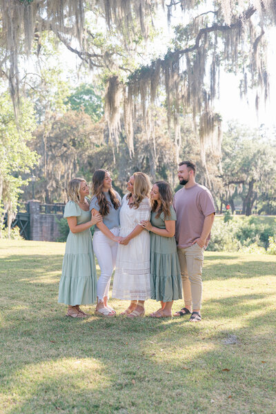 Mom and adult children giggle with one another under oak trees for Palmetto Bluff Photographer Lamp and Light Photography. 