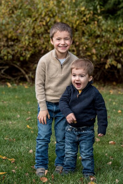 two brothers pose next to one another, smiling and having fun