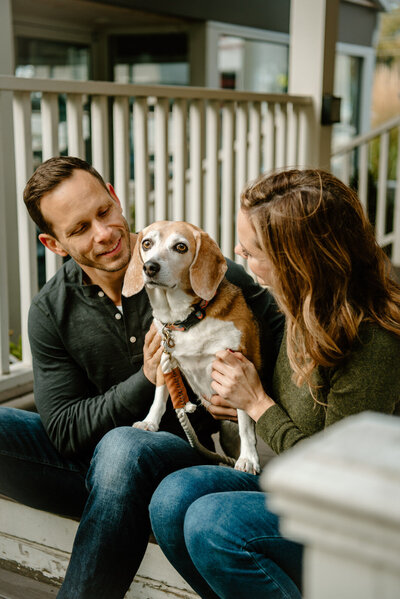 couple holding their beagle dog between them
