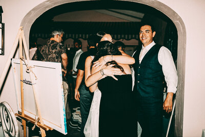 couple who just received their live event portrait hugging Brin on their wedding day