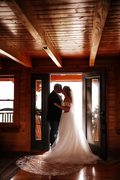Couple standing in doorway, silhouette against sunlight