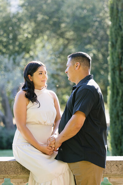 Bride and groom looking at each other while bride is sitting and groom is standing at Filoli Historic Garden 