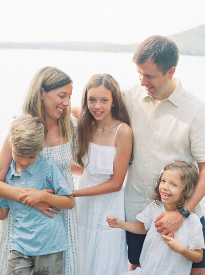 Young family snuggles together on a lake's shore in Central Arkansas, captured on film