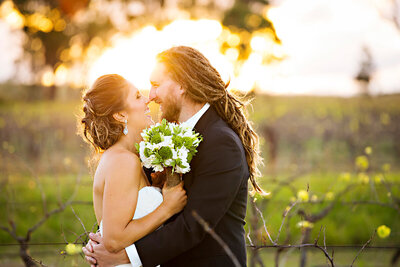 Photo of a bride and groom hugging at sunset