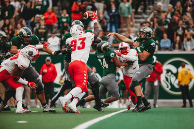 Colorado State University Rams football player throwing a ball during a game at Canvas Stadium in Fort Collins, Colorado, showcasing the action and energy of college football.