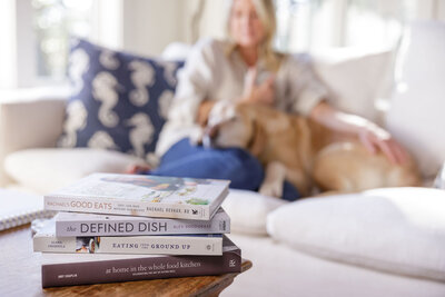 Kathy sitting on a couch with her dog, emphasizing a relaxed lifestyle and oral health connection to overall wellness.