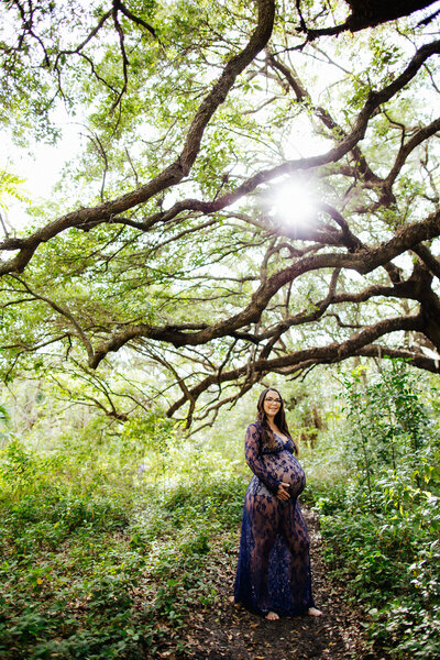 Pregnant mom posing in lace gown in the woods for her Pregnancy Session with Tiny House Photo in Asheville Blue Ridge Mountains