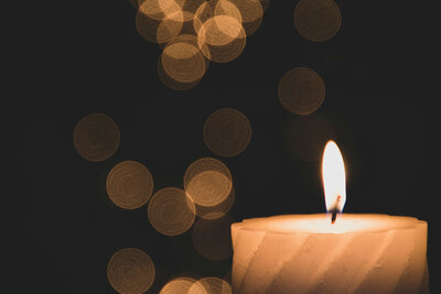 Close-up candle with bokeh lights behind. 
