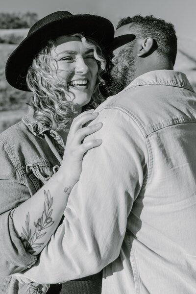 Couple smiling together while standing in the rolling hills of san jose