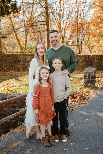 Family poses on bride with leaves falling for their photo session in Bethlehem PA 