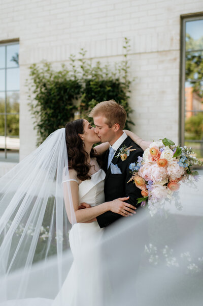 Bride and groom kissing with bouquet South Bend