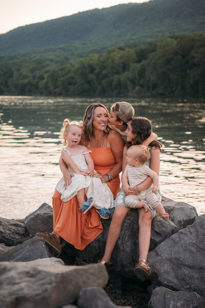 mom and daughter snuggling outdoors at golden hour