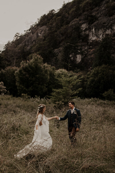 bride and groom dancing in field