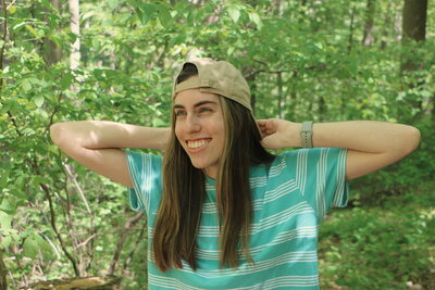 Julia in the woods smiling and looking into the distance